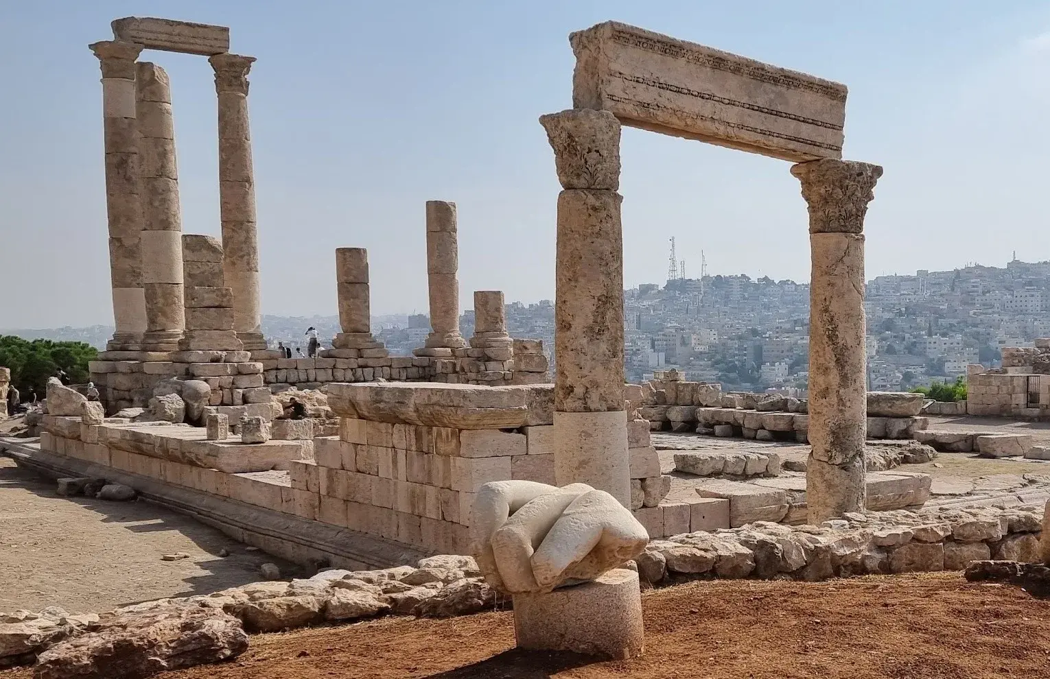 Mano de la estatua de Hércules y templo al fondo en la Ciudadela de Amán