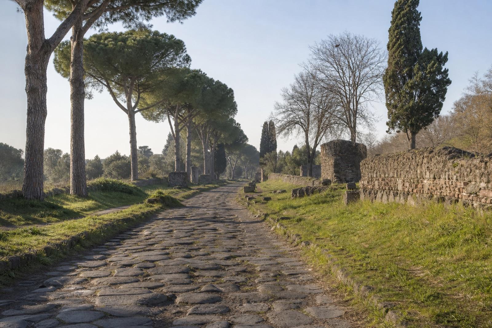 Calzada antigua de la Vía Appia entre pinos y restos arqueológicos
