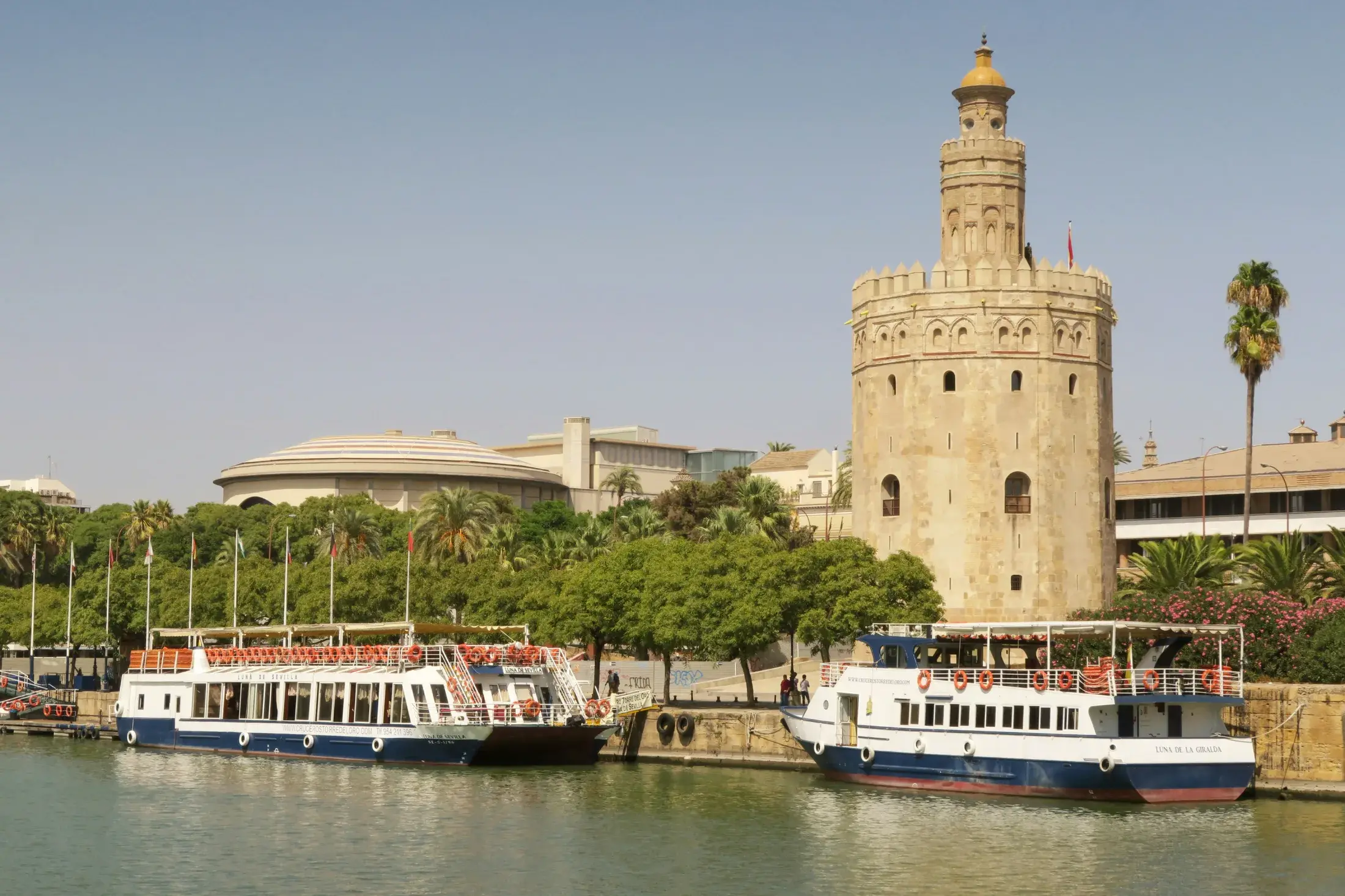 Torre del Oro de Sevilla junto al río Guadalquivir y embarcaciones